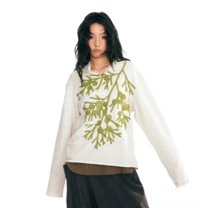 Three-quarter front view of oatmeal cotton v-neck pullover with green botanical embroidery and layered ribbed top