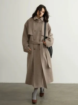 Oatmeal oversized belted wool blend trench coat worn by model in full front three-quarter studio view