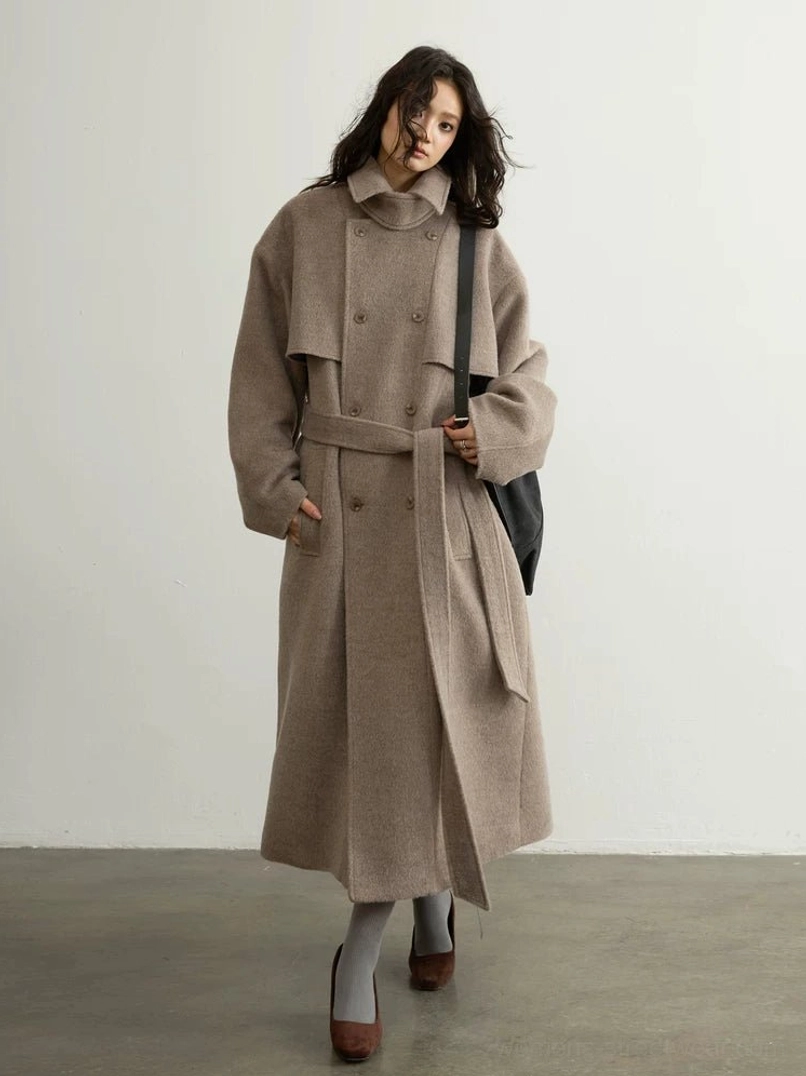 Oatmeal oversized belted wool blend trench coat worn by model in full front three-quarter studio view