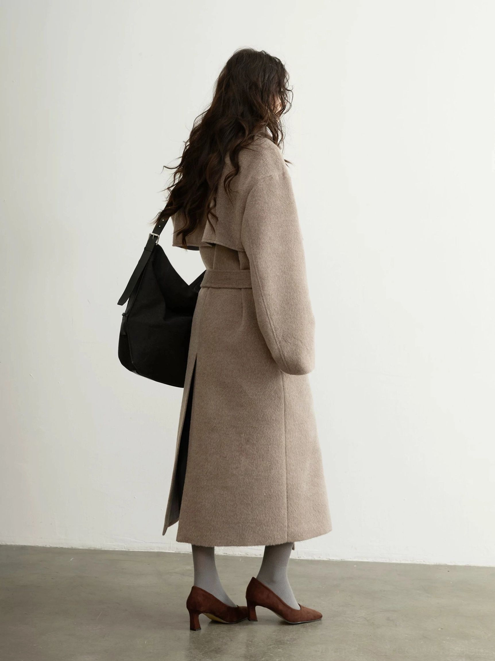 Back side view of oatmeal oversized wool blend overcoat with tied waist sash and full-length hem
