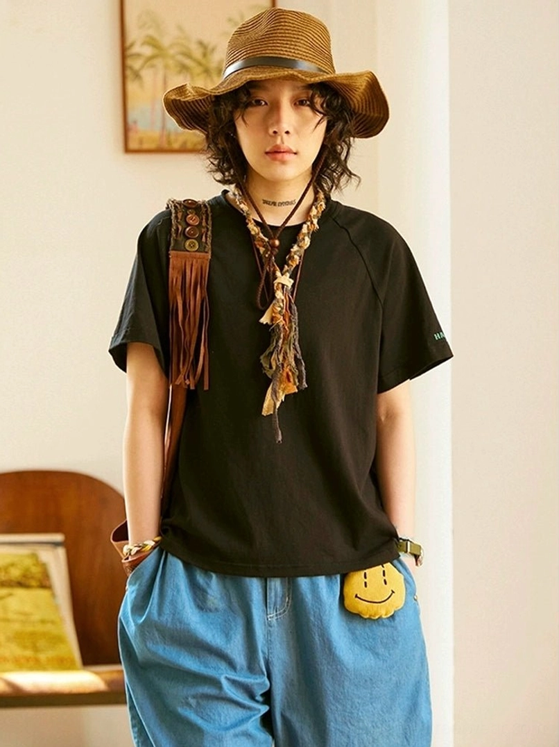 Obsidian black raglan sleeve t-shirt full body front view in minimalist streetwear styling with neutral accessories