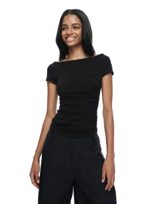 Black off-shoulder backless fitted streetwear T-shirt styled with black wide-leg trousers in a front studio view