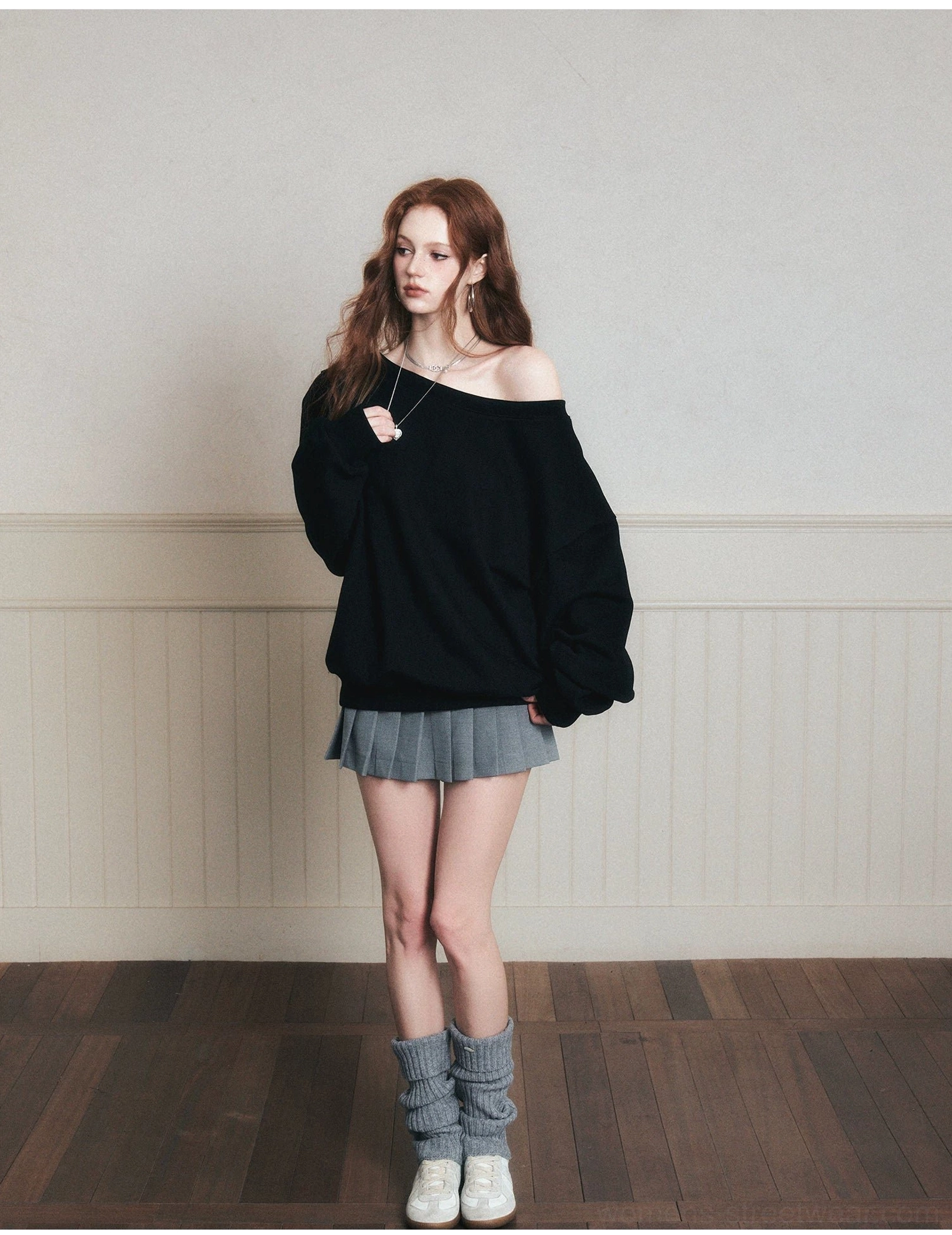 Black oversized boat neck sweatshirt with gray pleated skirt leg warmers and white sneakers