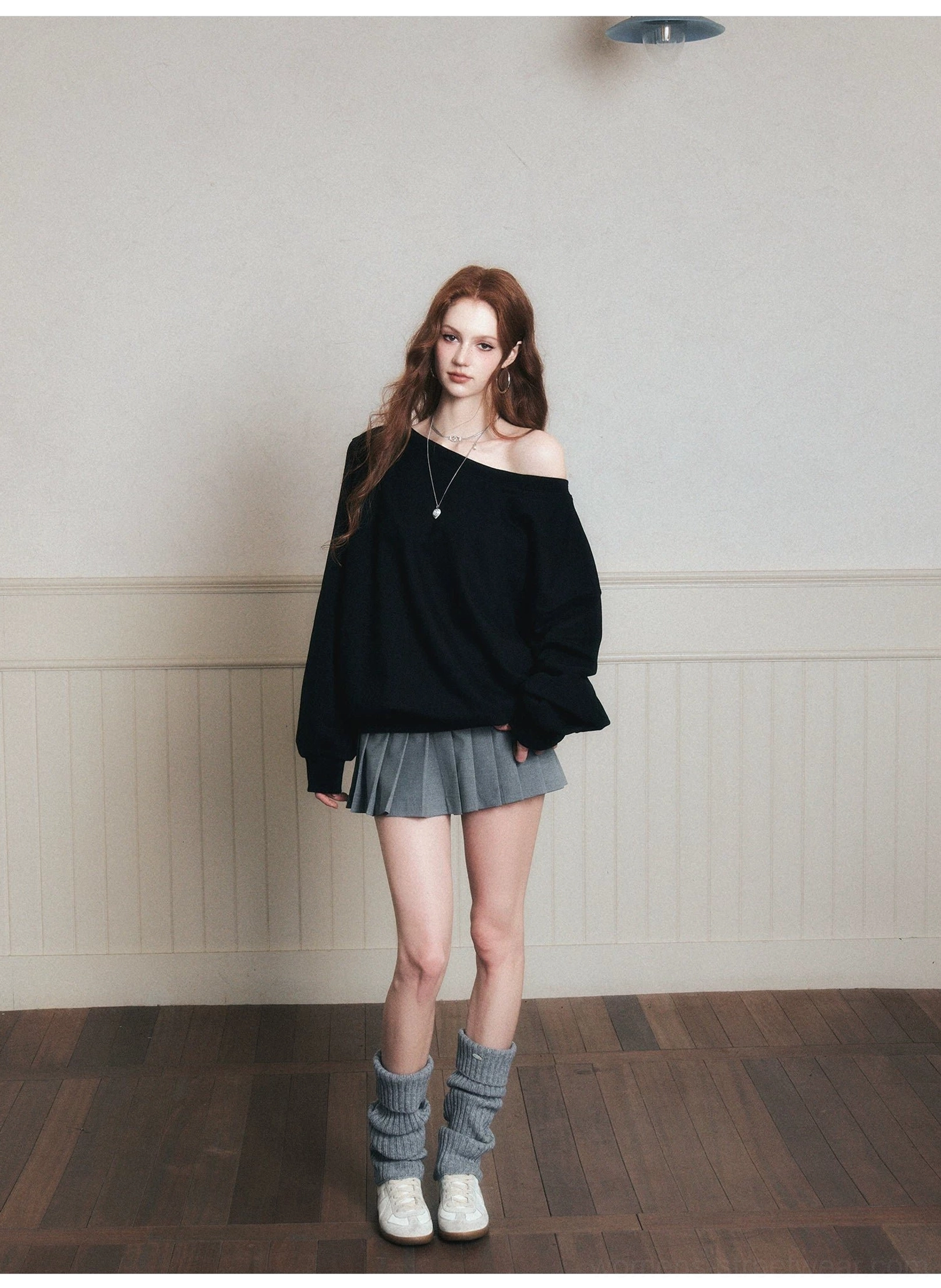 Black oversized off-shoulder pullover sweatshirt showing relaxed dropped shoulder silhouette