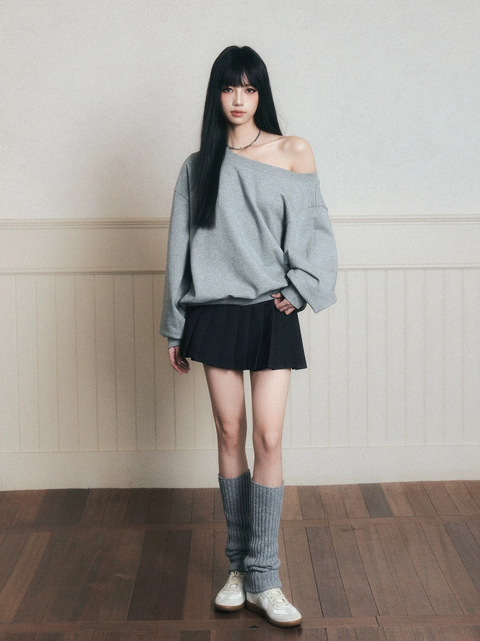 Heather gray boat neck oversized sweatshirt with black pleated skirt and gray leg warmers