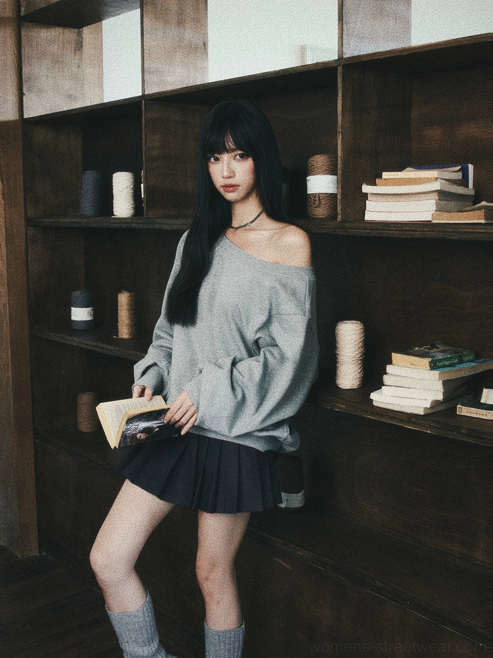 Gray oversized off-shoulder sweatshirt styled with black pleated mini skirt in campus fashion look