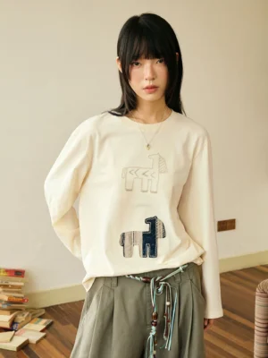 Off white abstract horse patch long sleeve T-shirt shown from the back with green pleated wide leg pants in a Korean streetwear outfit