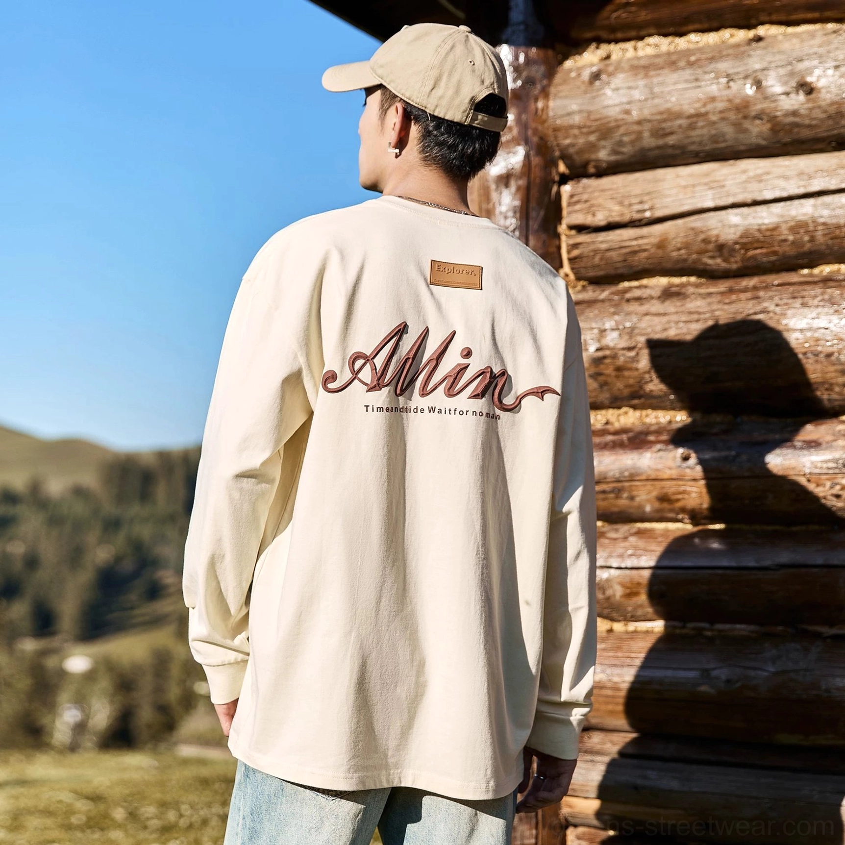 Off white oversized cotton long sleeve tee with reddish brown alpine script graphic and relaxed crew neck