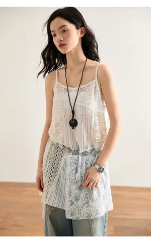 Off-white asymmetric crochet lace cami top with mixed open-knit panels, floral lace details, spaghetti straps, and an irregular long hem shown from the front