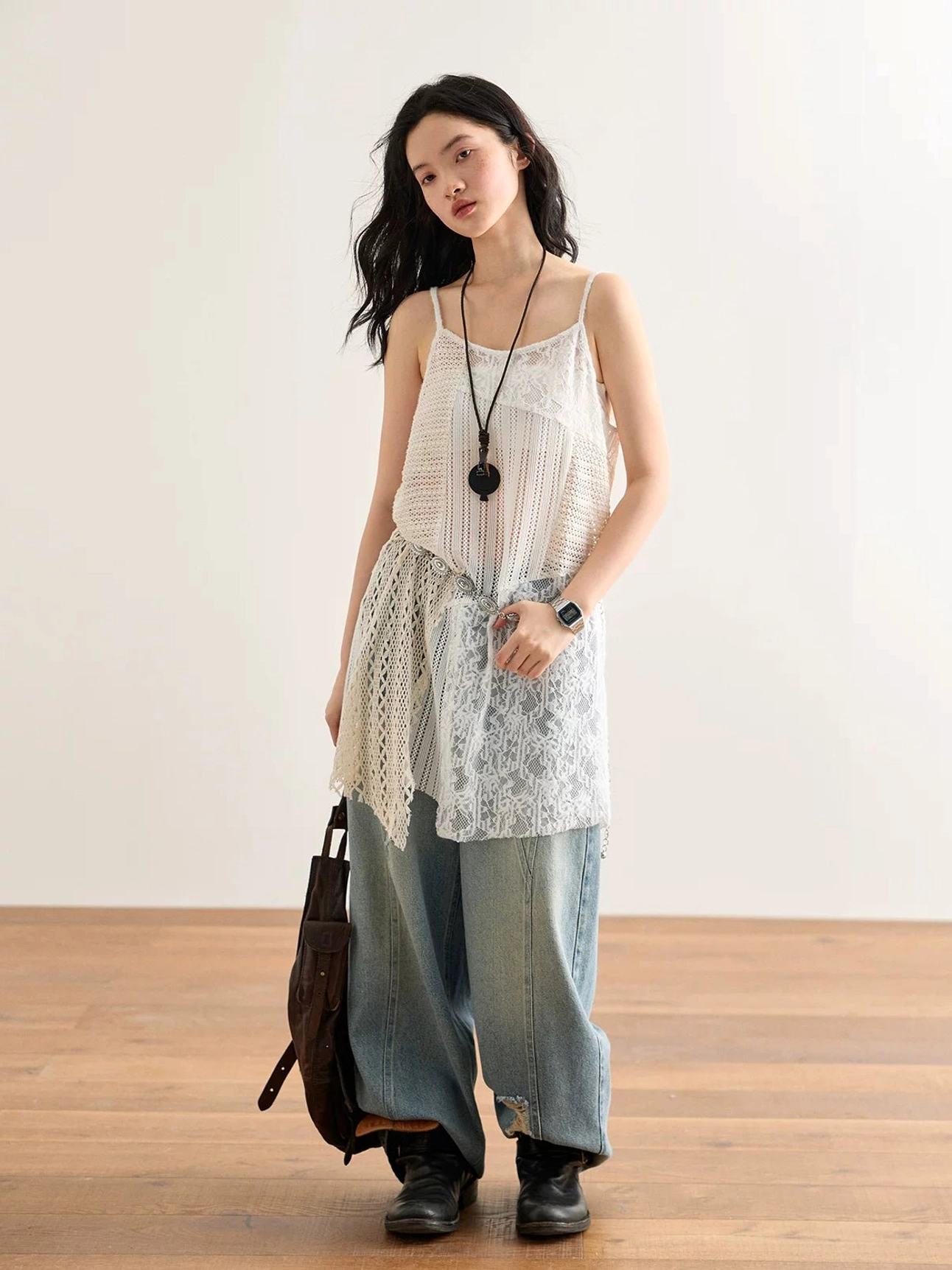 Off-white asymmetric crochet lace cami top showing the full layered silhouette, delicate spaghetti straps, mixed lace textures, and flowing uneven hem