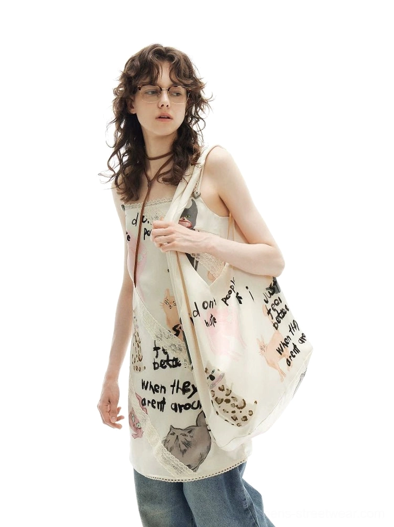 Model showing an off-white cat doodle hobo tote bag paired with a matching printed camisole top and wide-leg jeans