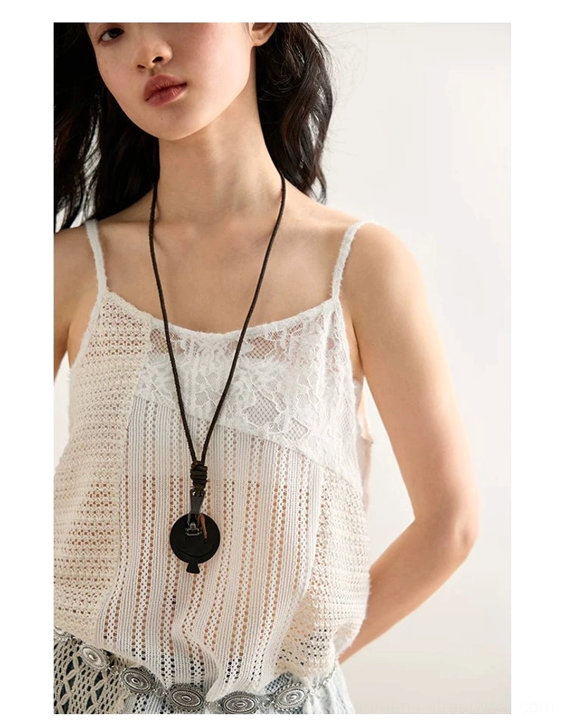 Detailed upper-body view of off-white open-knit crochet and floral lace cami top styled with a vintage metal belt and pendant necklace