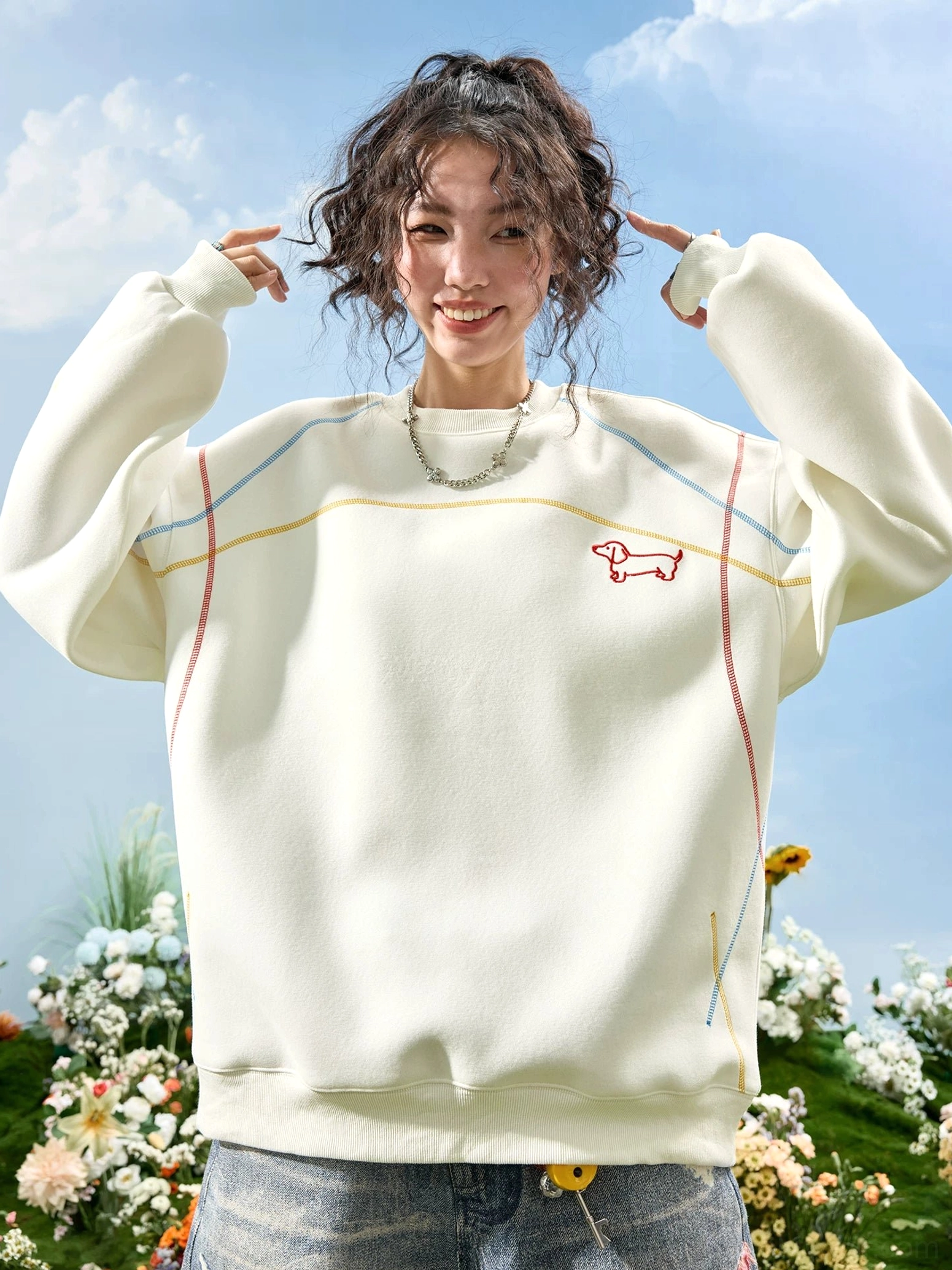 Off-white dachshund embroidered oversized sweatshirt with red chest graphic and colorful contrast topstitching worn by a female model