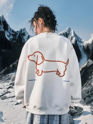 Female model wearing an off-white oversized dachshund embroidered sweatshirt with large orange back graphic outdoors