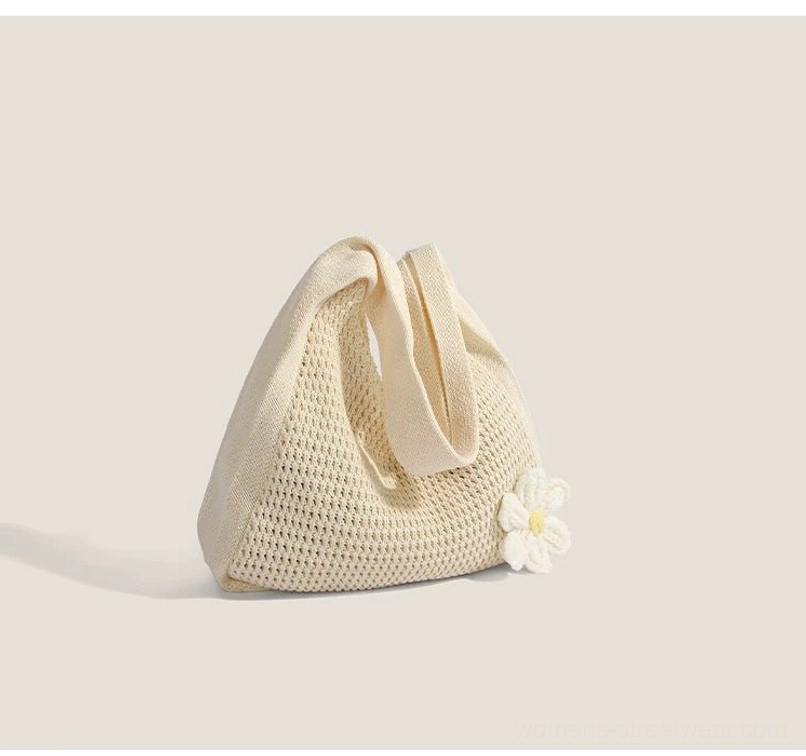 Back view of an off white daisy crochet hobo bag with folded wide shoulder strap and compact shape
