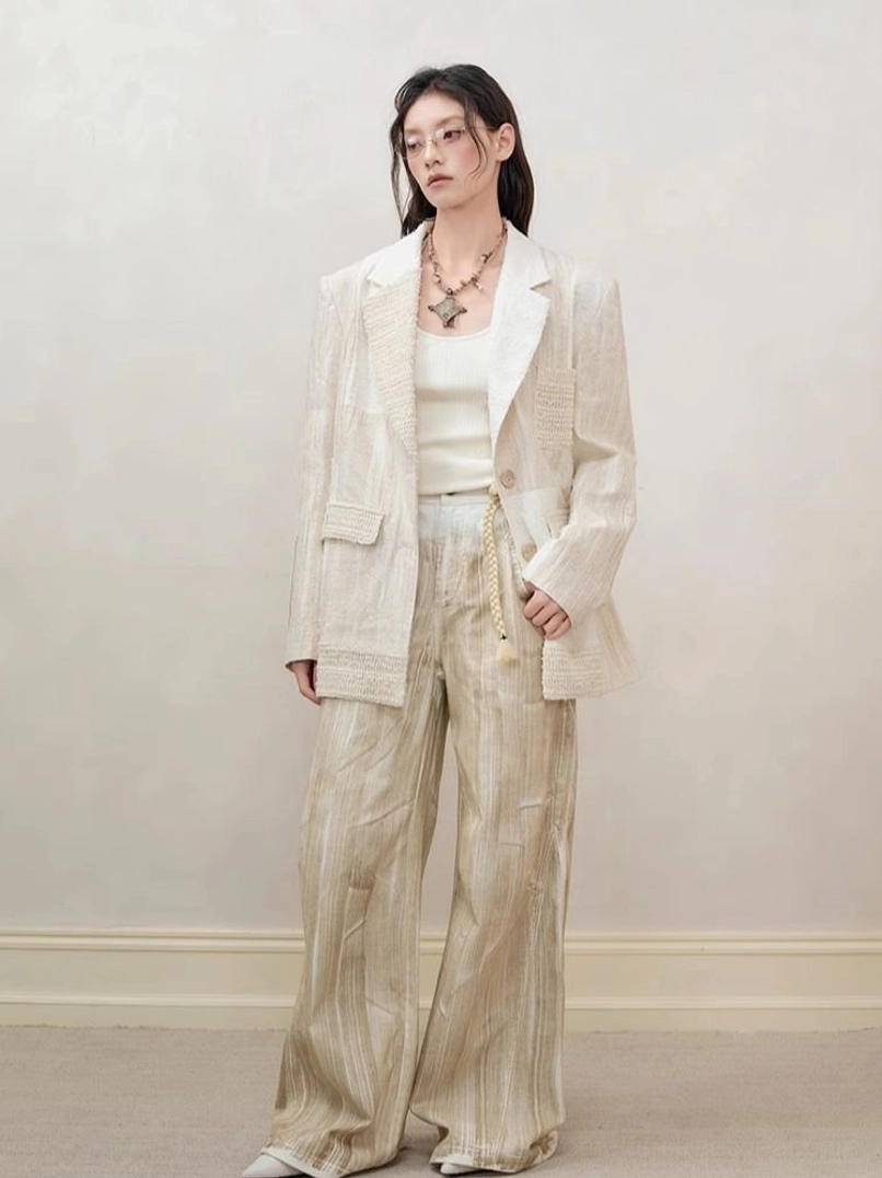 Off-white distressed cutout blazer for women styled with striped wide-leg trousers and tank top front view