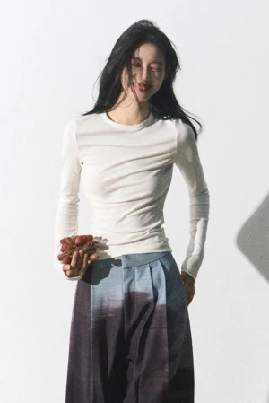 Three-quarter view of an off-white fitted crew neck ribbed long sleeve Korean streetwear top