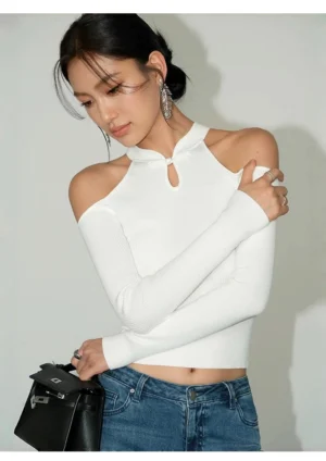 Off White ribbed cold-shoulder keyhole knit top with long sleeves styled with blue jeans and leather handbag