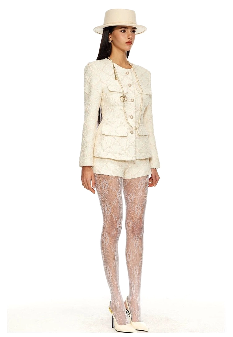 Off-white women's tweed blazer and matching mini shorts suit styled with lace tights white heels and pearl chain detail