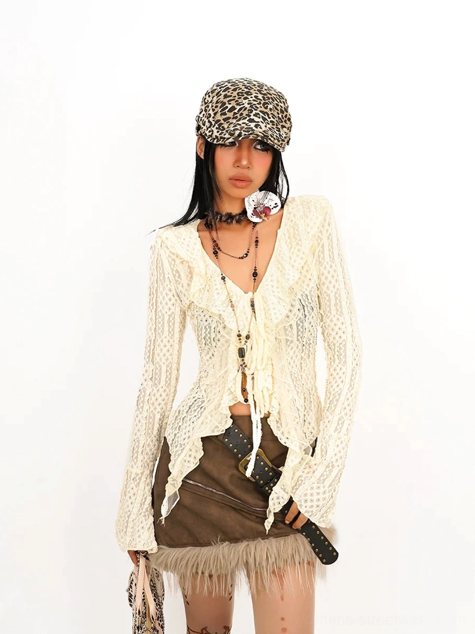 Profile view of off-white crochet tie-front ruffle top highlighting the V-neck, asymmetric hem, and flared cuff details