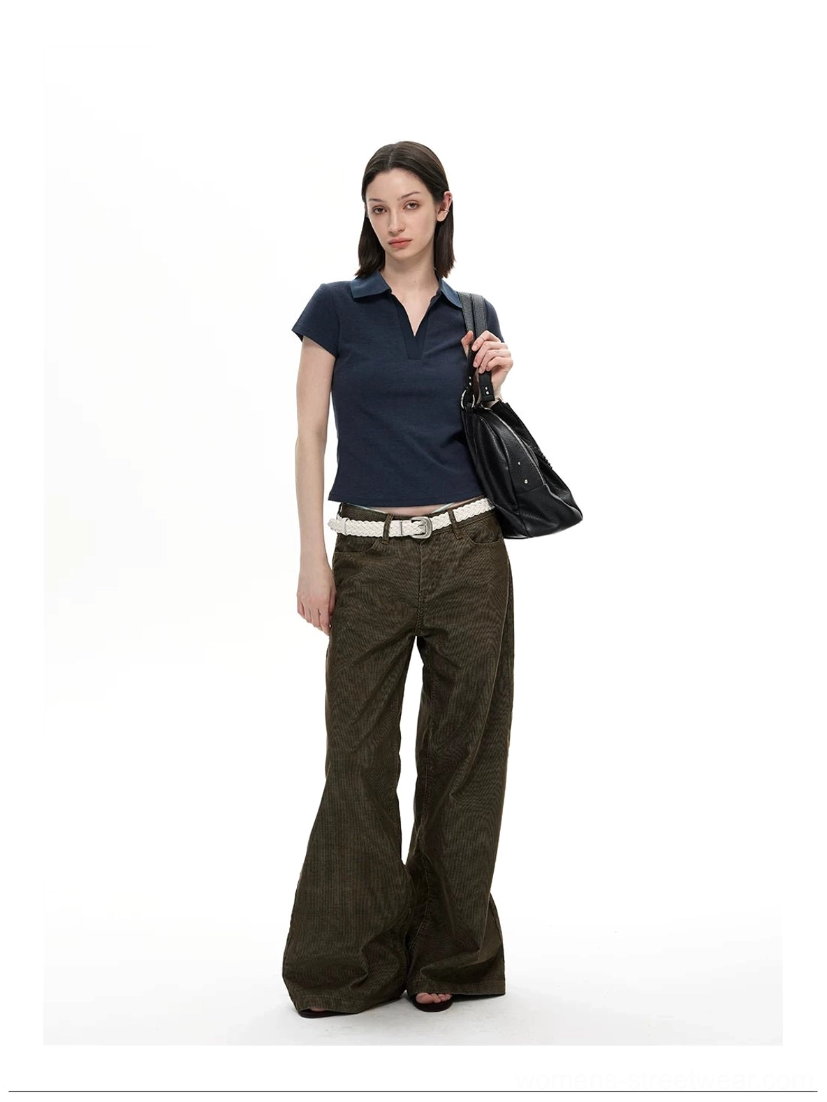 Olive corduroy wide leg trousers styled with navy polo shirt black handbag and white belt in streetwear look