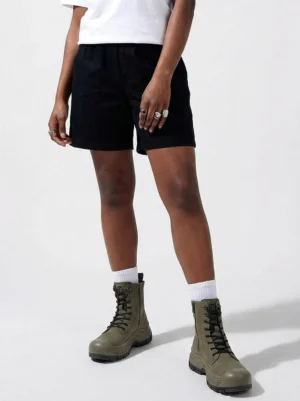 Model wearing olive green reinforced toe platform combat boots with shorts and white crew socks