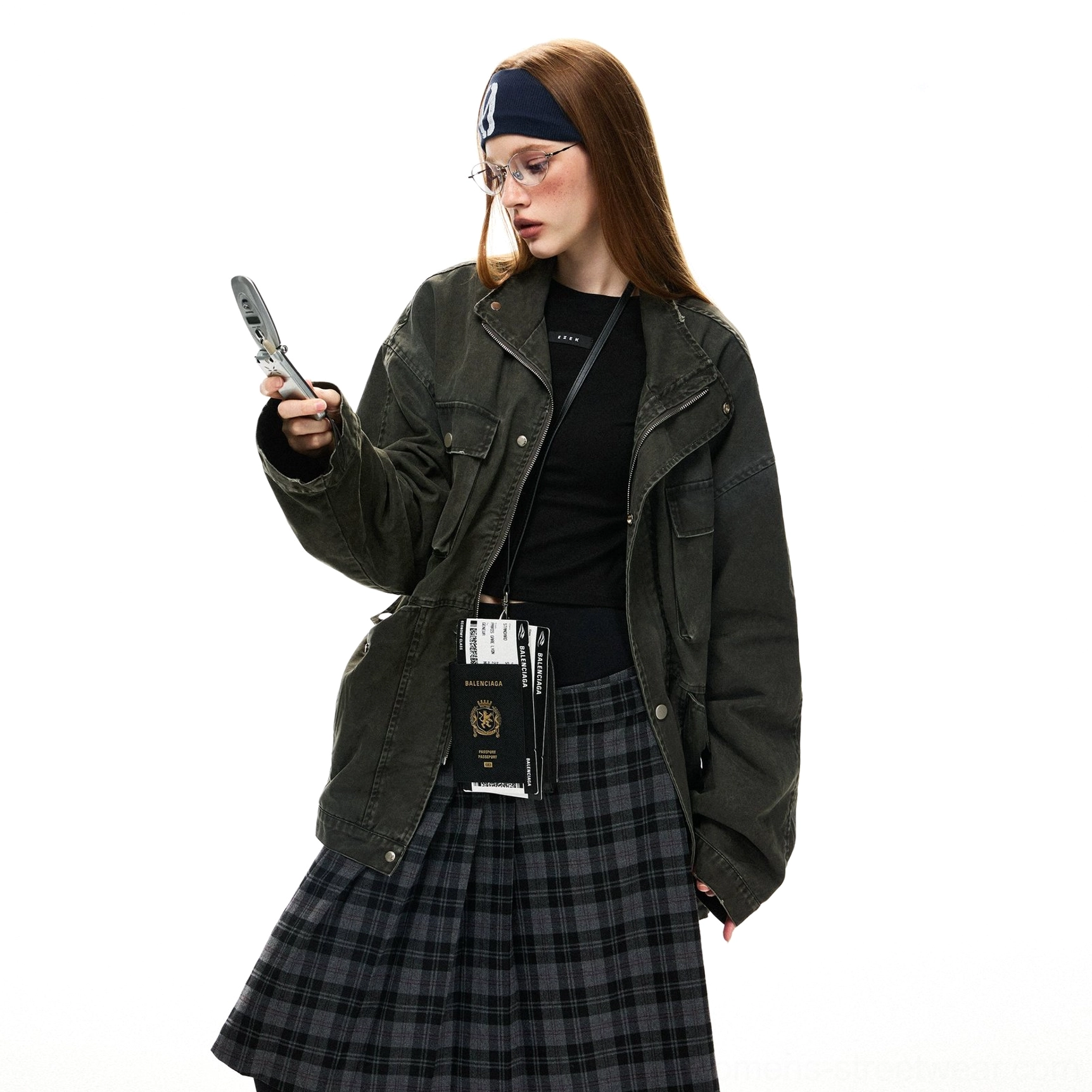 Half-body view of a woman wearing an oversized olive green utility jacket over a fitted black top with visible flap pockets and crossbody styling