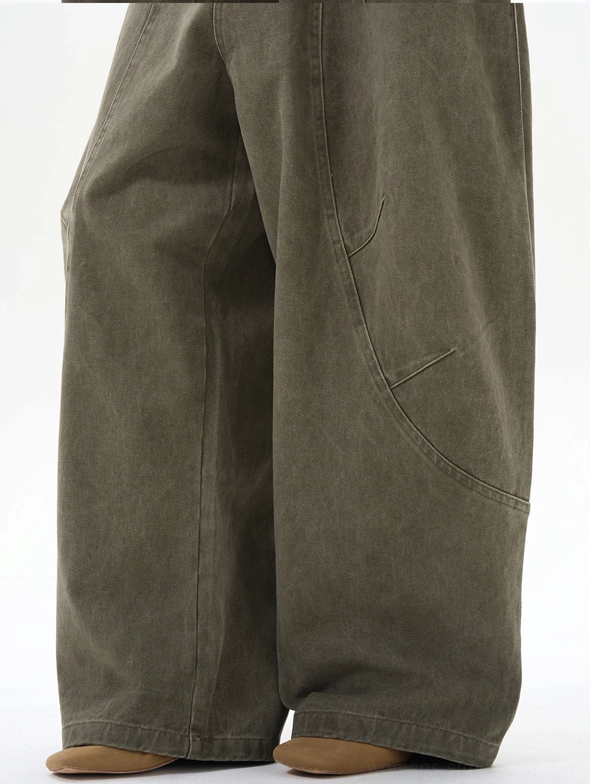 Close-up of sturdy cotton olive cargo pants fabric with wide leg hem and curved cargo pocket construction
