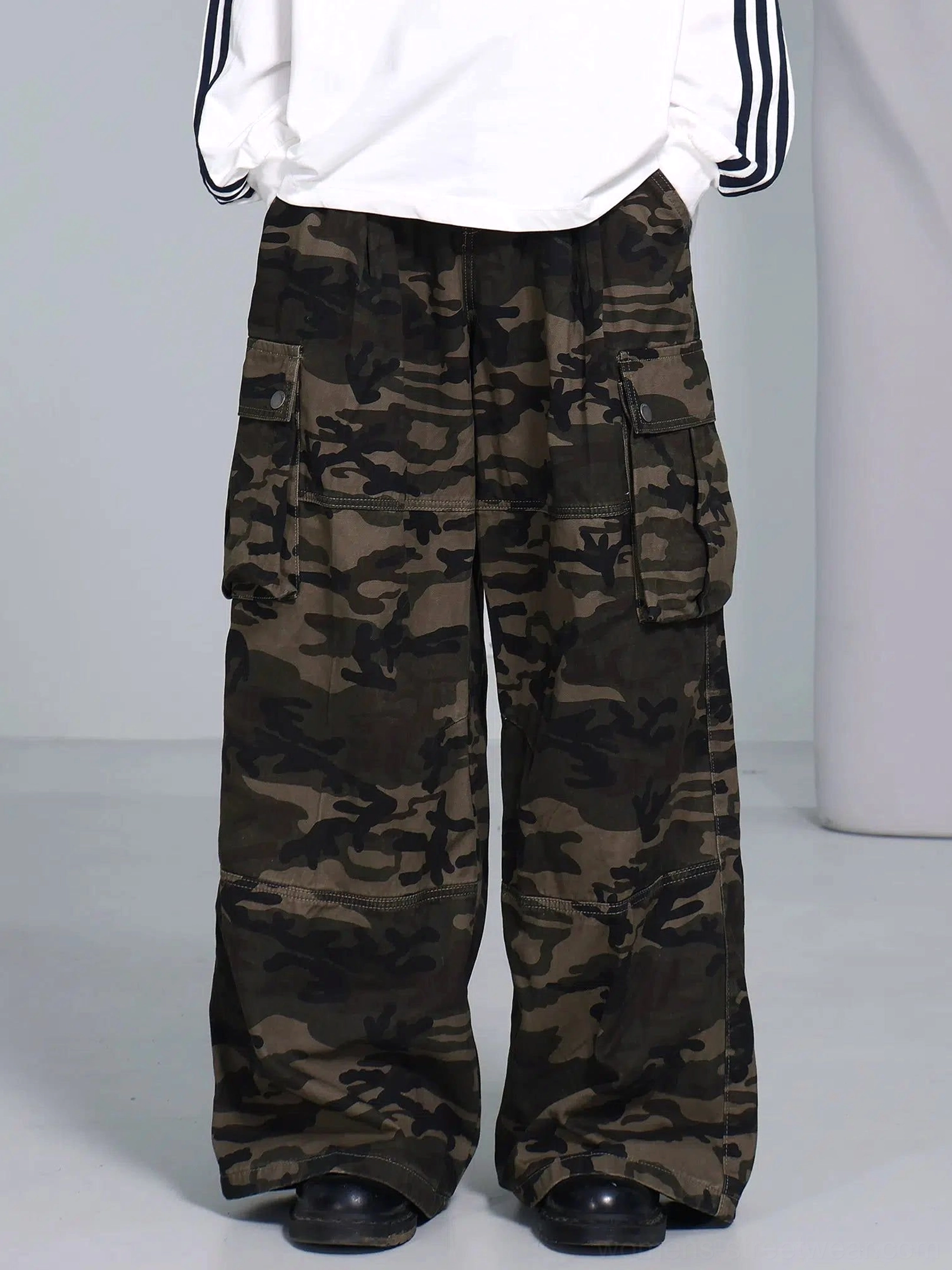 Full front view of olive woodland camouflage cargo pants with symmetrical side pockets and oversized wide leg streetwear fit