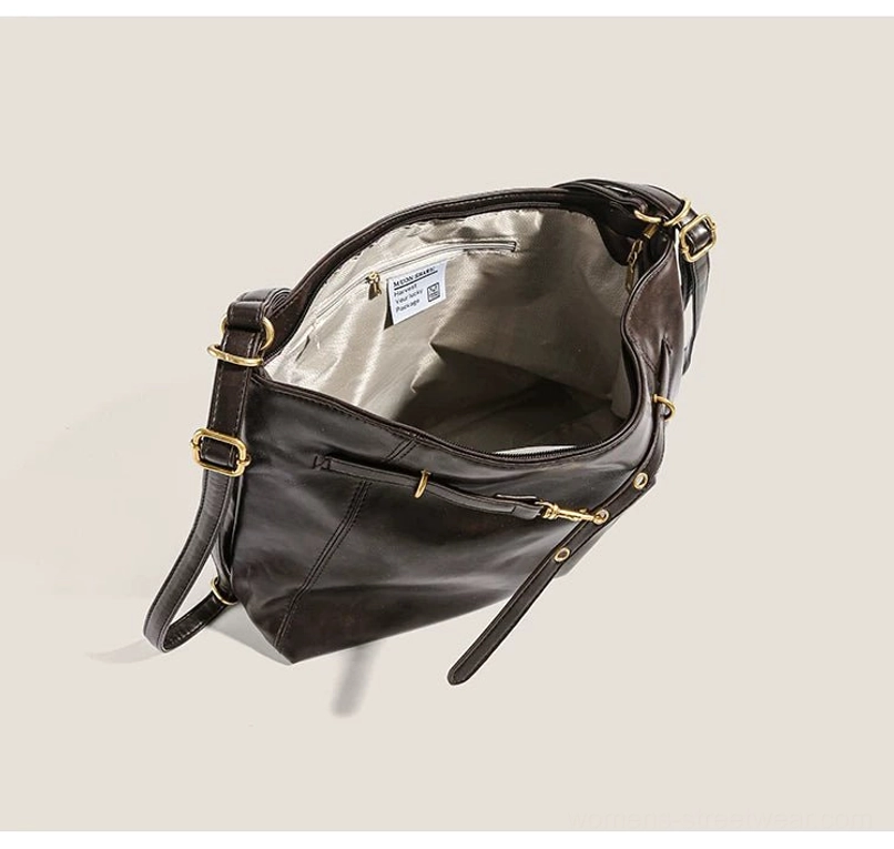 Open brown buckle hobo shoulder bag showing light gray polyester lining, built-in interior zipper pocket, and gold-tone exterior strap hardware