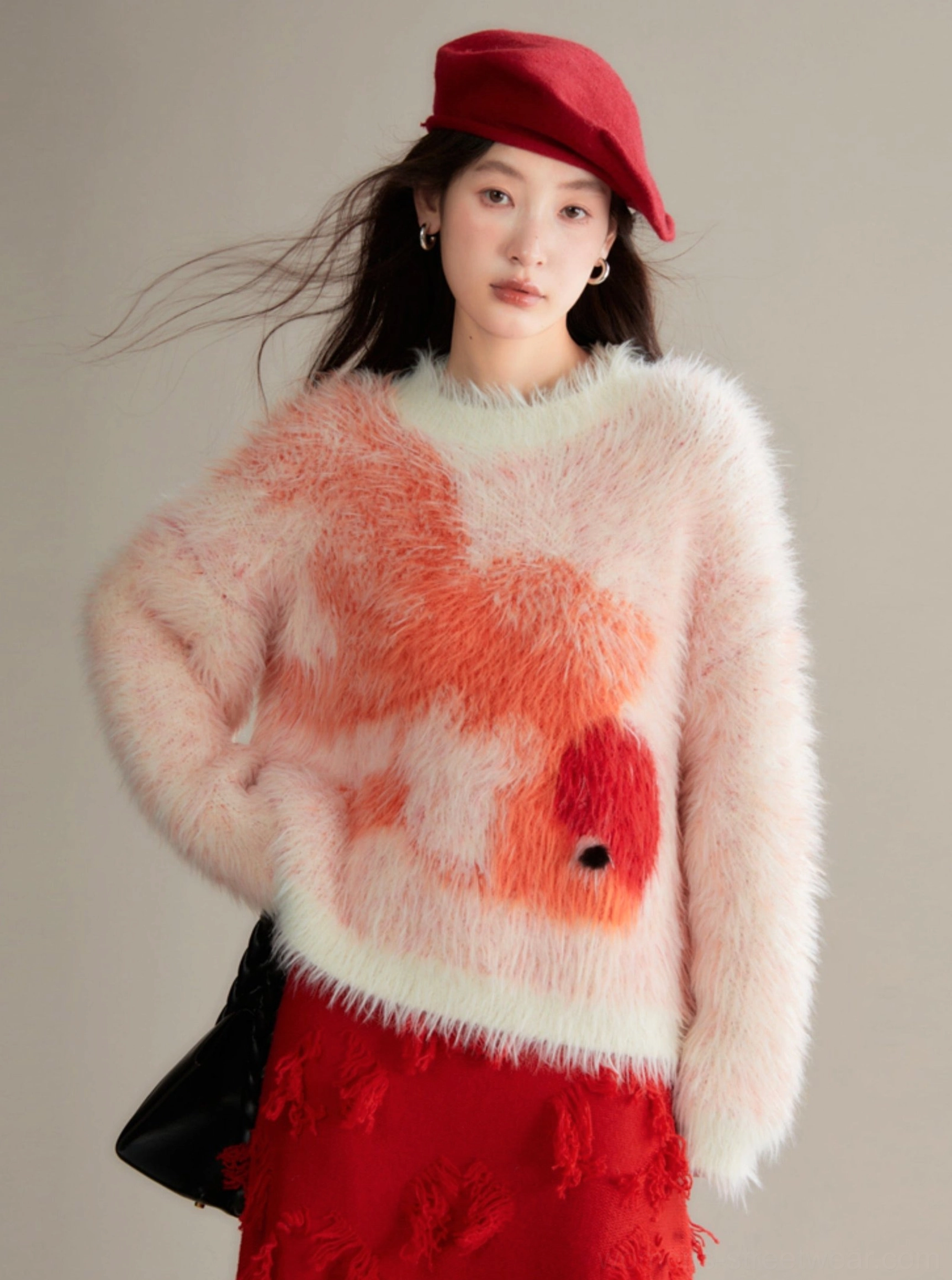 Side view of orange-red koi fuzzy knit sweater showing relaxed oversized fit, plush texture, crew neckline, and long sleeves