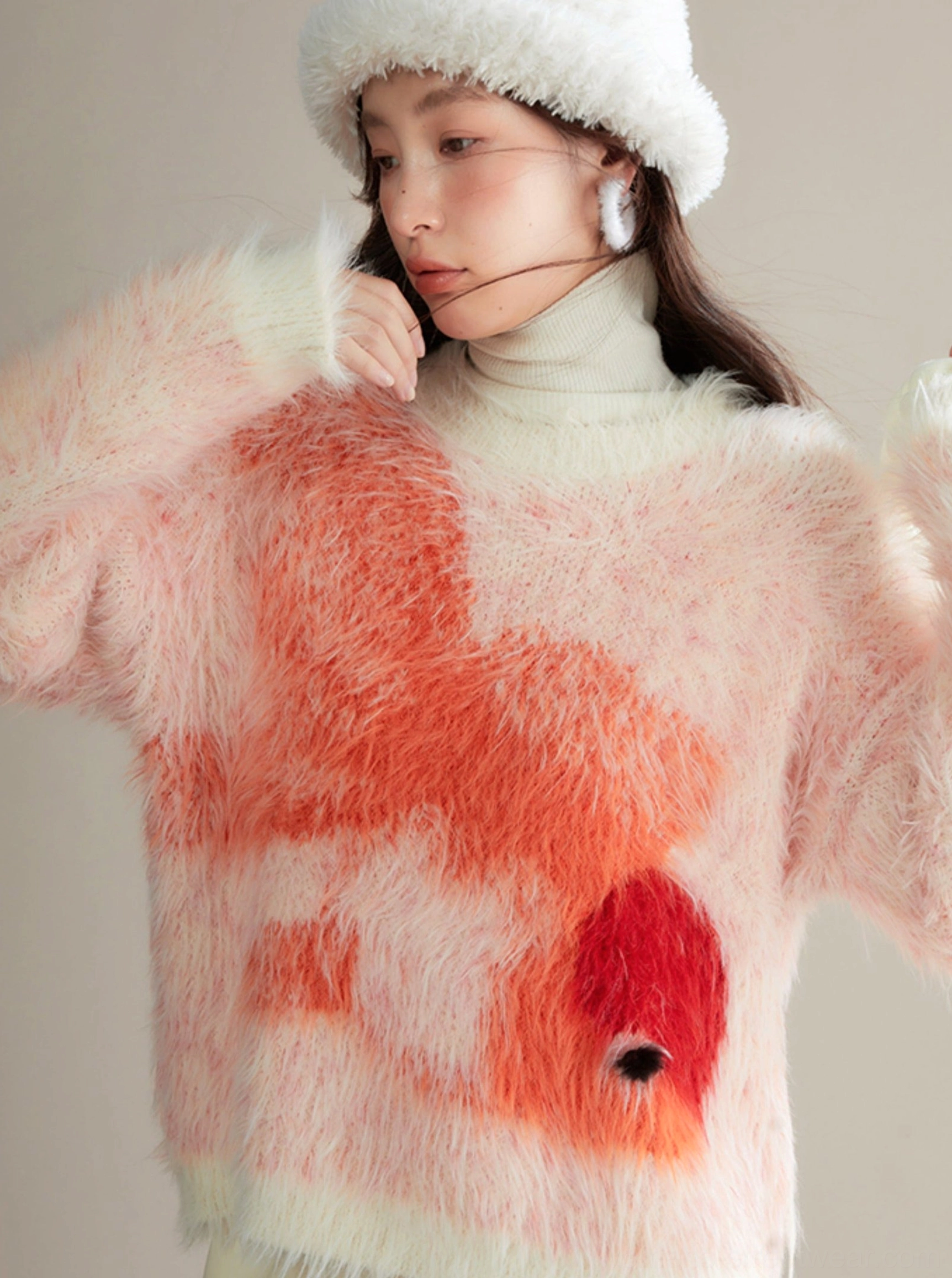 Close-up of detailed orange-red koi print on dense plush fuzzy knit fabric with soft pale background