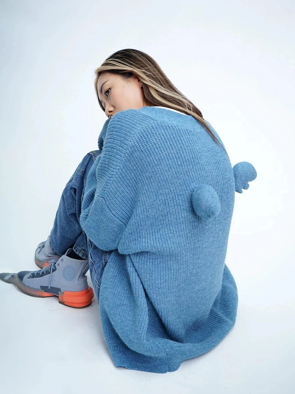 Denim blue oversized fuzzy knit cardigan with angel wing and pom-pom back detail on female model