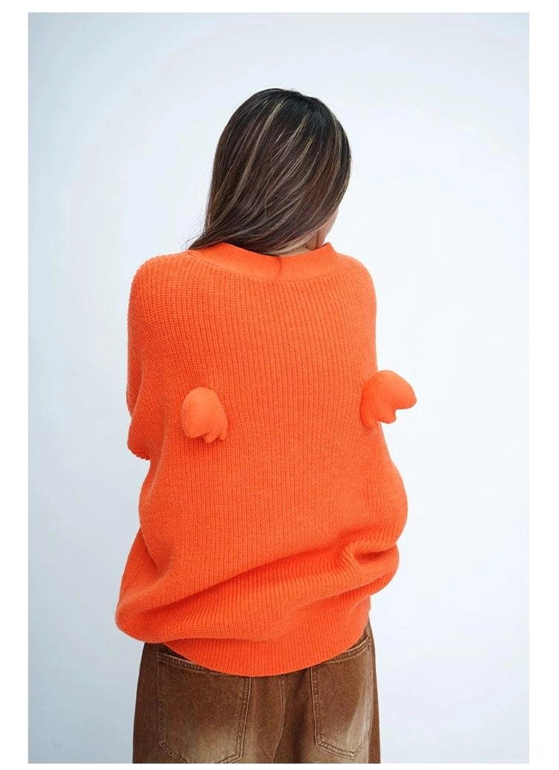 Orange oversized fuzzy knit cardigan back view showing angel wing and round pom-pom decoration