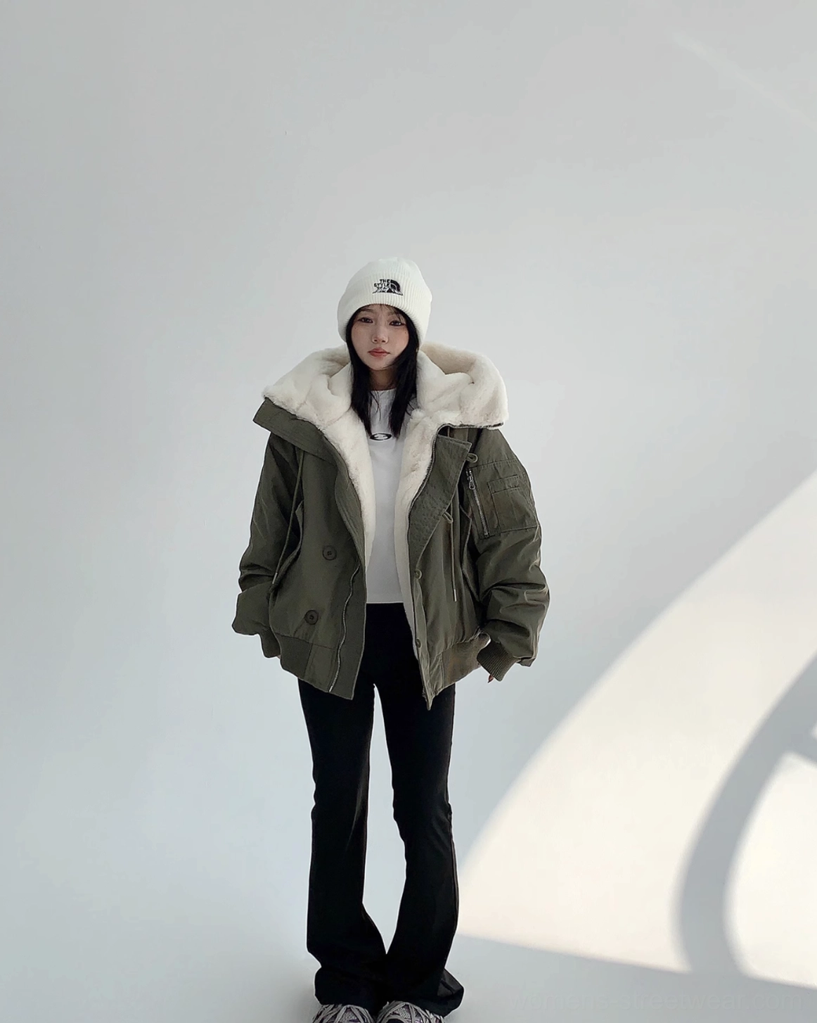Full front view of relaxed oversized army green bomber jacket worn open to reveal the warm faux-shearling lining