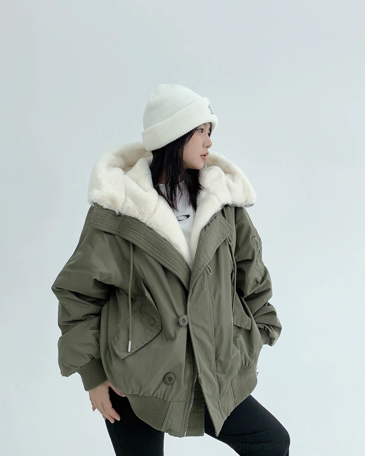 Three-quarter view of oversized army green bomber jacket with plush off-white hood trim and wide ribbed cuffs