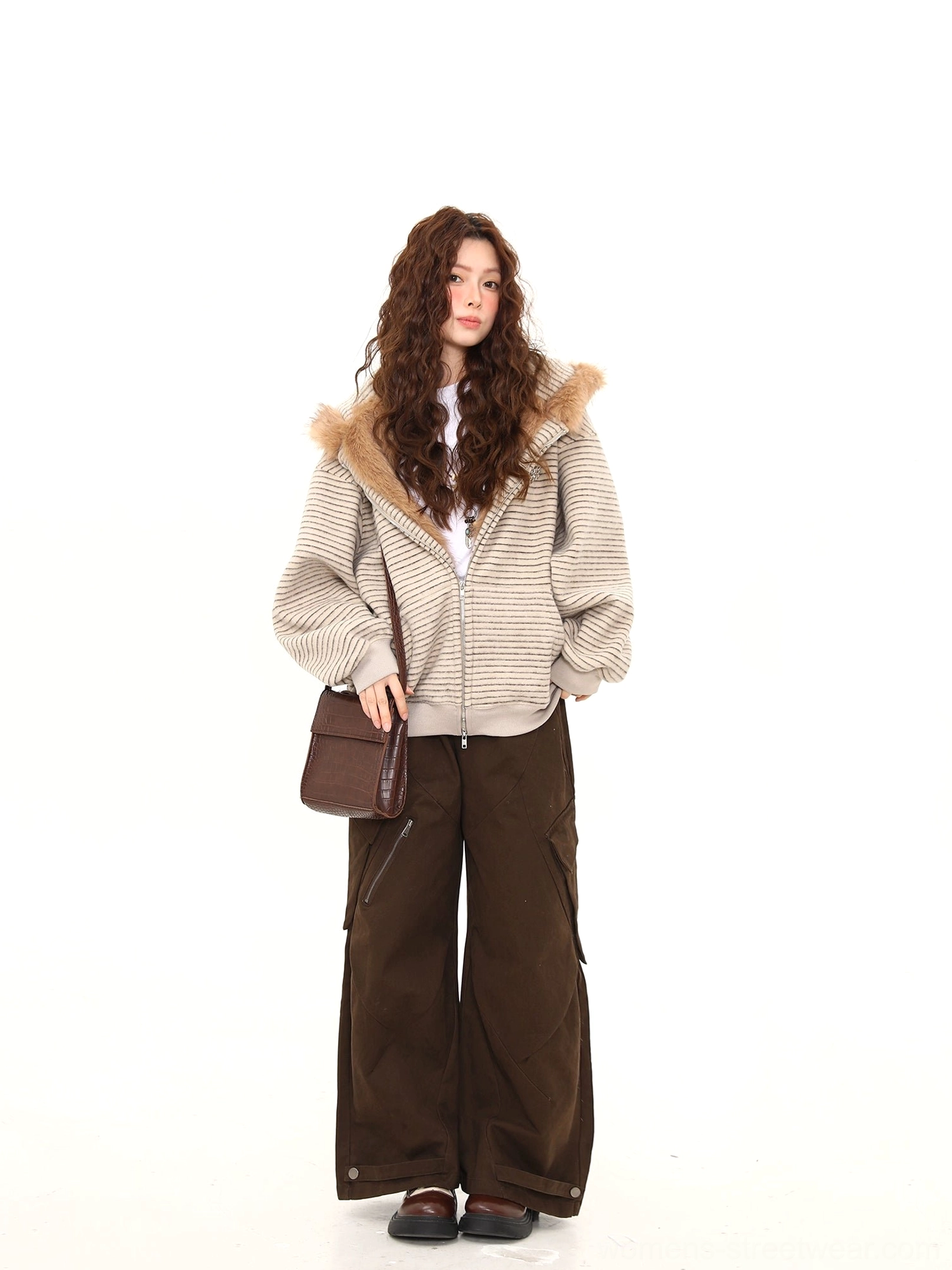 Full front view of an oversized beige striped bunny-ear zip-up hoodie with brown faux-fur hood trim styled with wide-leg cargo pants and loafers