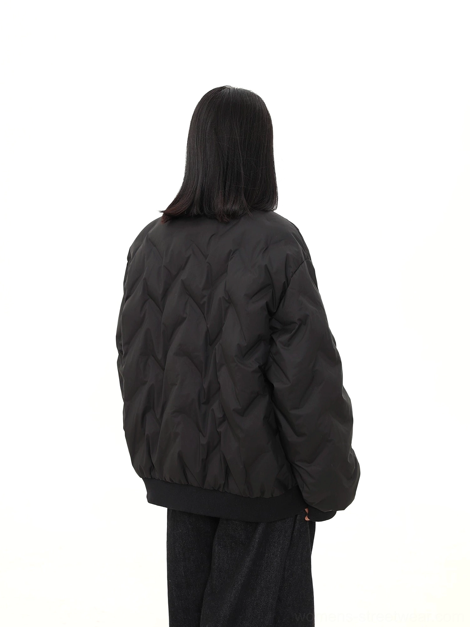 Back view of an oversized black chevron quilted puffer bomber jacket with ribbed hem and relaxed drop shoulder silhouette