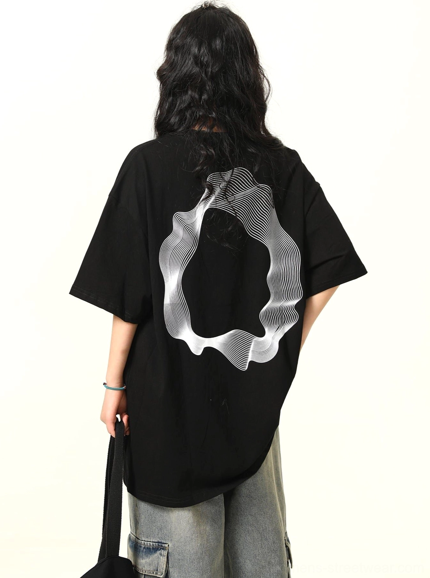 Back view of oversized black cotton streetwear tee featuring large white wavy abstract ring graphic print