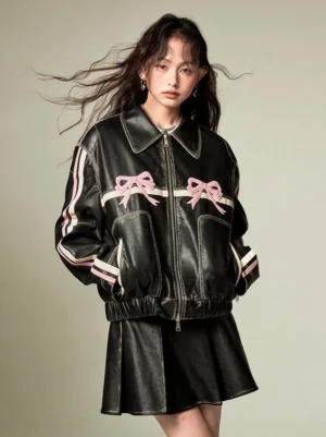 Oversized black faux leather bow jacket with pink chest bows contrast striped sleeves and relaxed cropped streetwear fit