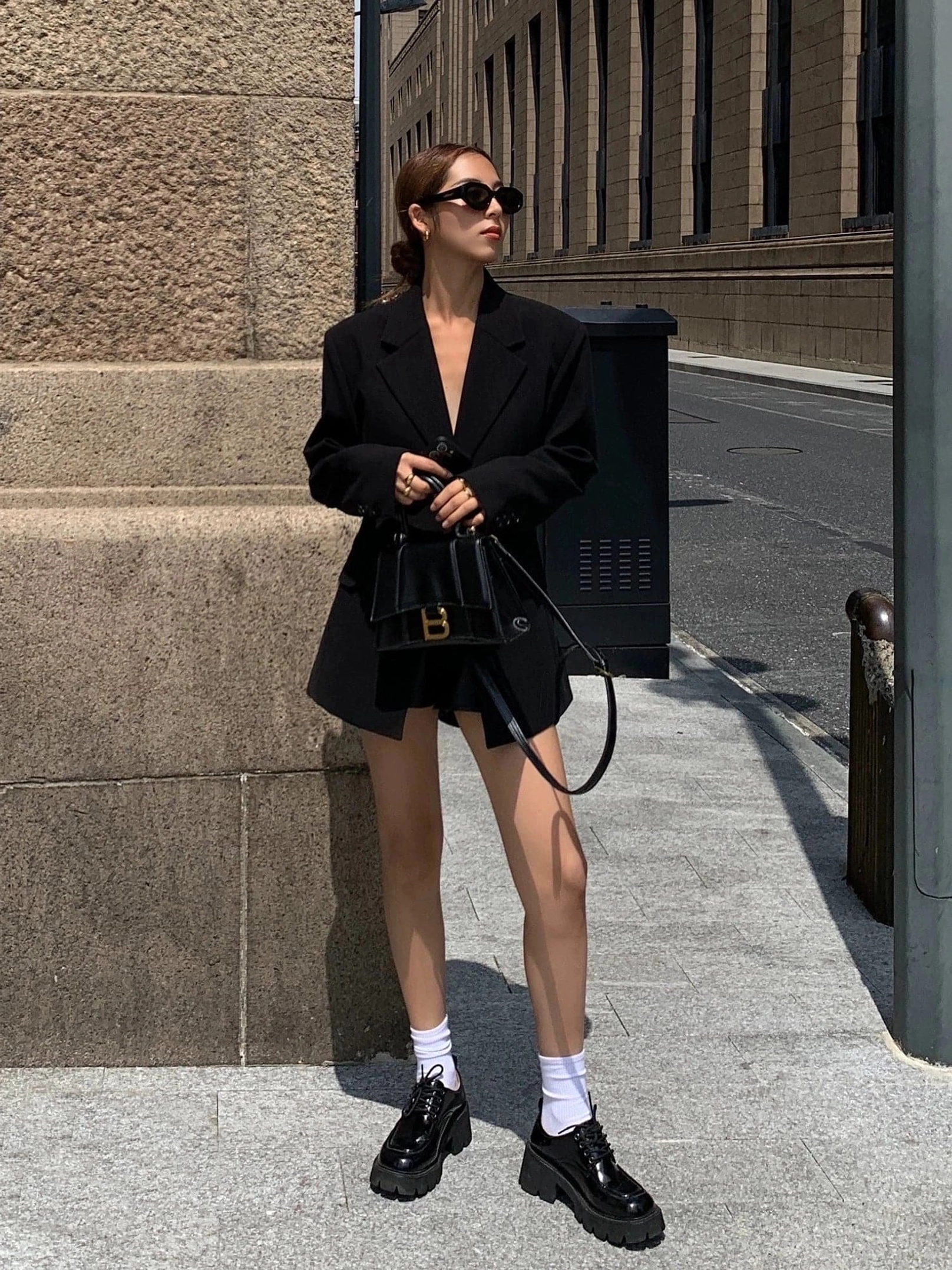 Oversized black blazer jacket styled with tailored shorts loafers and crossbody bag for Seoul streetwear outfit