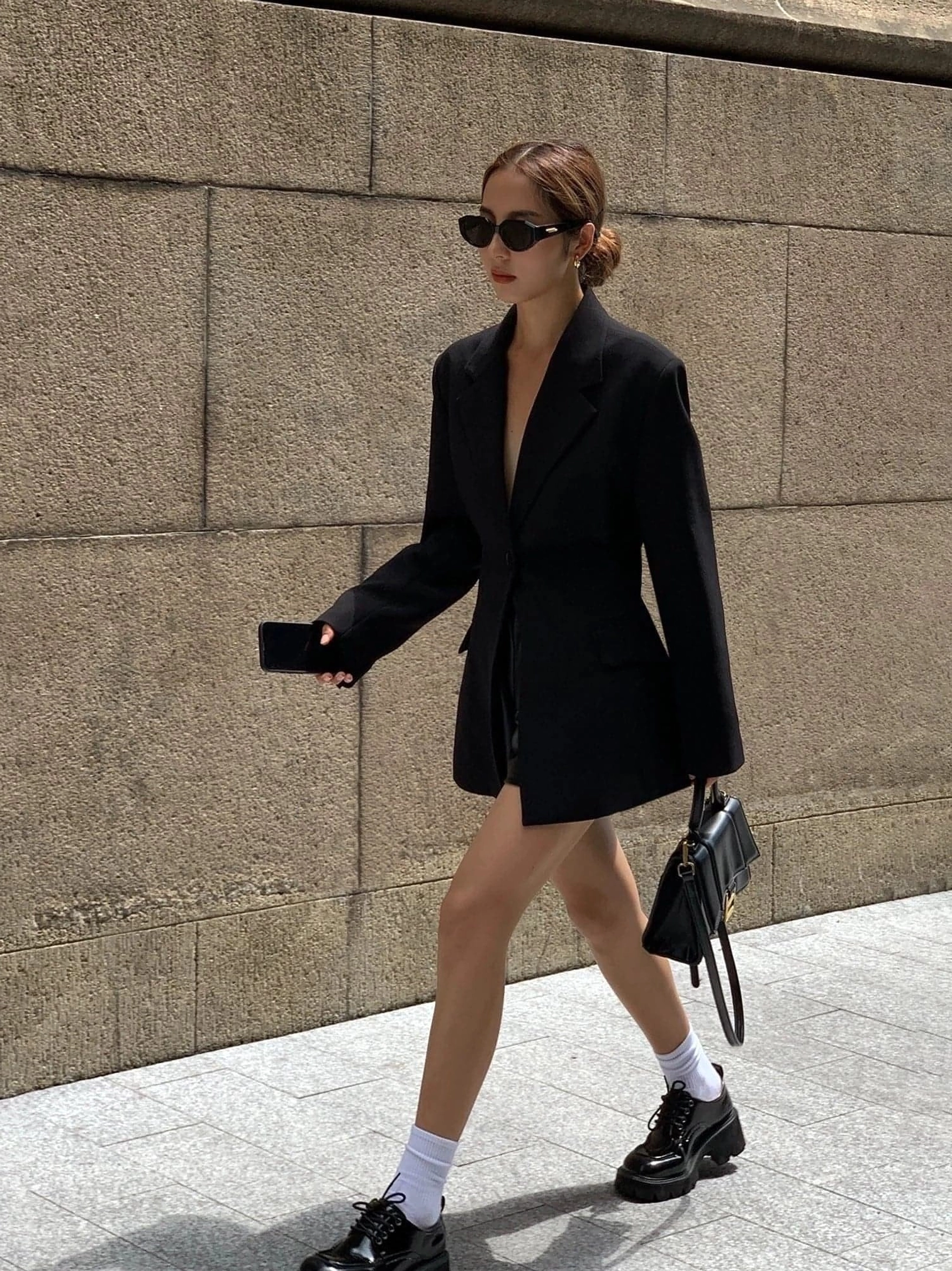 Side view of women's oversized black single-button blazer jacket with longline tailored streetwear fit