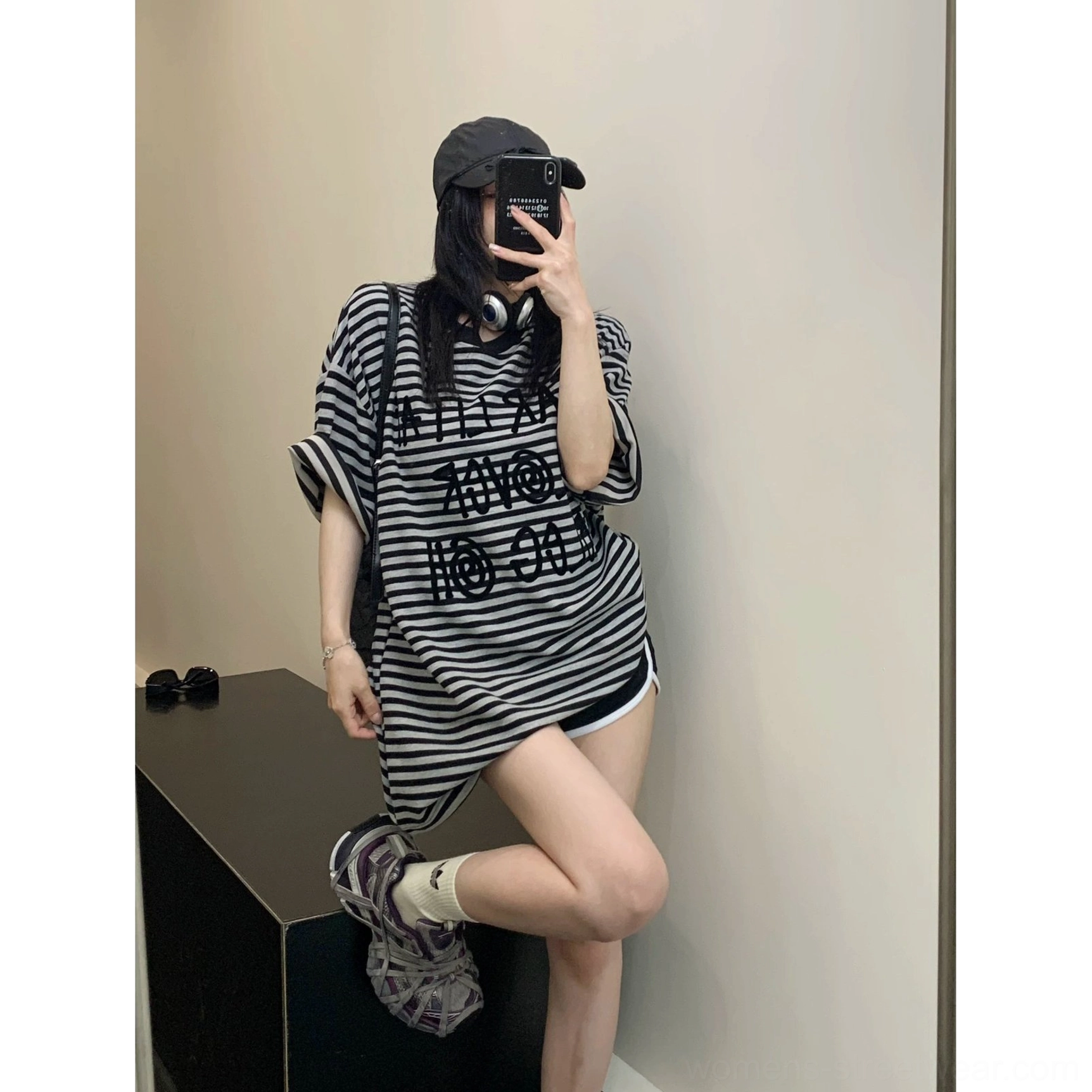 Full-body mirror look with an oversized black striped T-shirt, biker shorts, ankle socks, and sporty sneakers in casual Y2K streetwear style