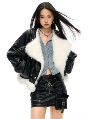 Black oversized vegan faux leather moto jacket with dramatic white faux fur collar and hem trim styled with a ribbed top and leather mini skirt