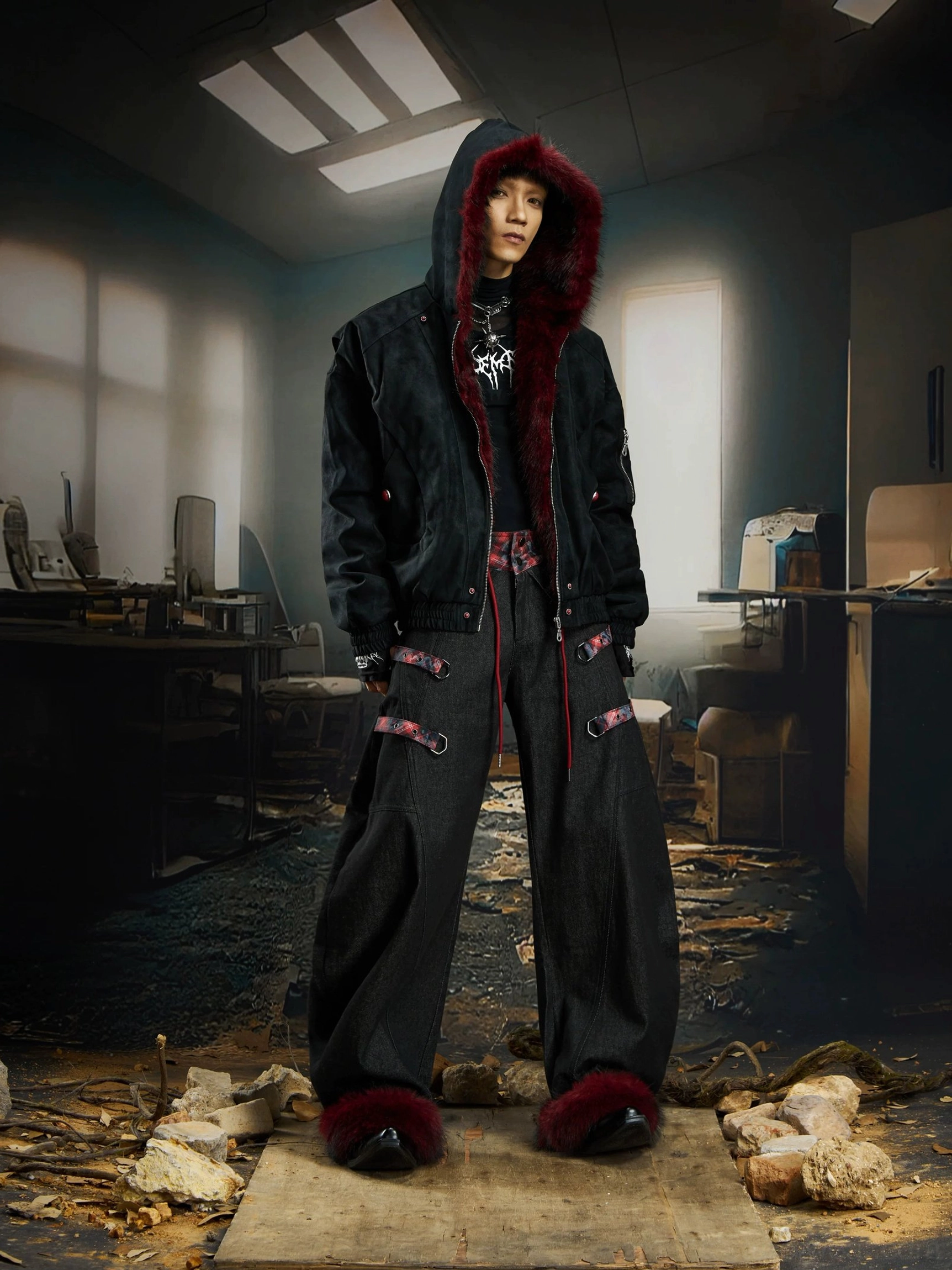 Male model styling oversized black wide-leg cargo pants with red plaid waistband dark red fur cuffs and hooded jacket