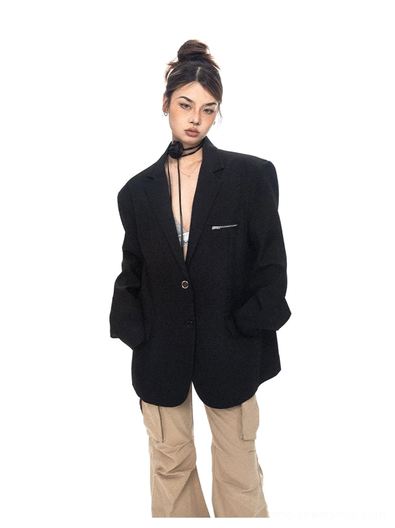 Front full-body view of an oversized black zip-pocket tailored blazer styled with a camisole and cargo pants for contemporary women's streetwear