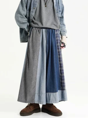 Blue oversized patchwork denim skirt pants shown from the front with wide-leg maxi streetwear silhouette and mixed striped denim panels