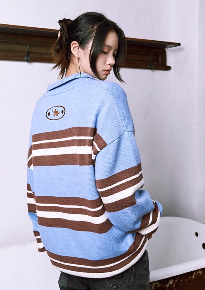 Back view of oversized blue striped polo knit sweater with oval embroidered badge