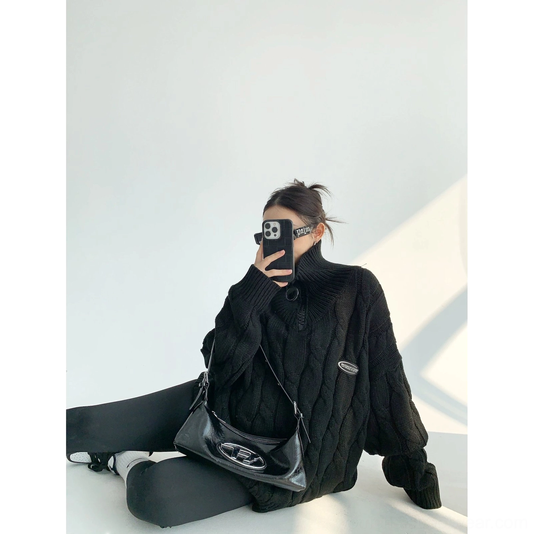 Black oversized cable knit quarter-zip sweater front view featuring drop shoulders and textured knit pattern
