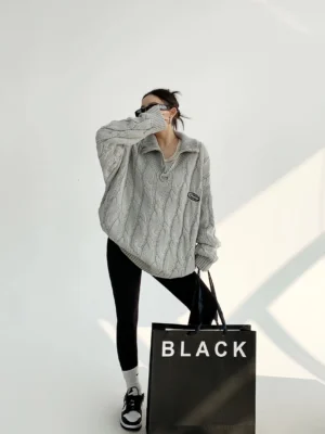 Gray oversized cable knit quarter-zip sweater styled with black leggings and sneakers in a full front streetwear outfit